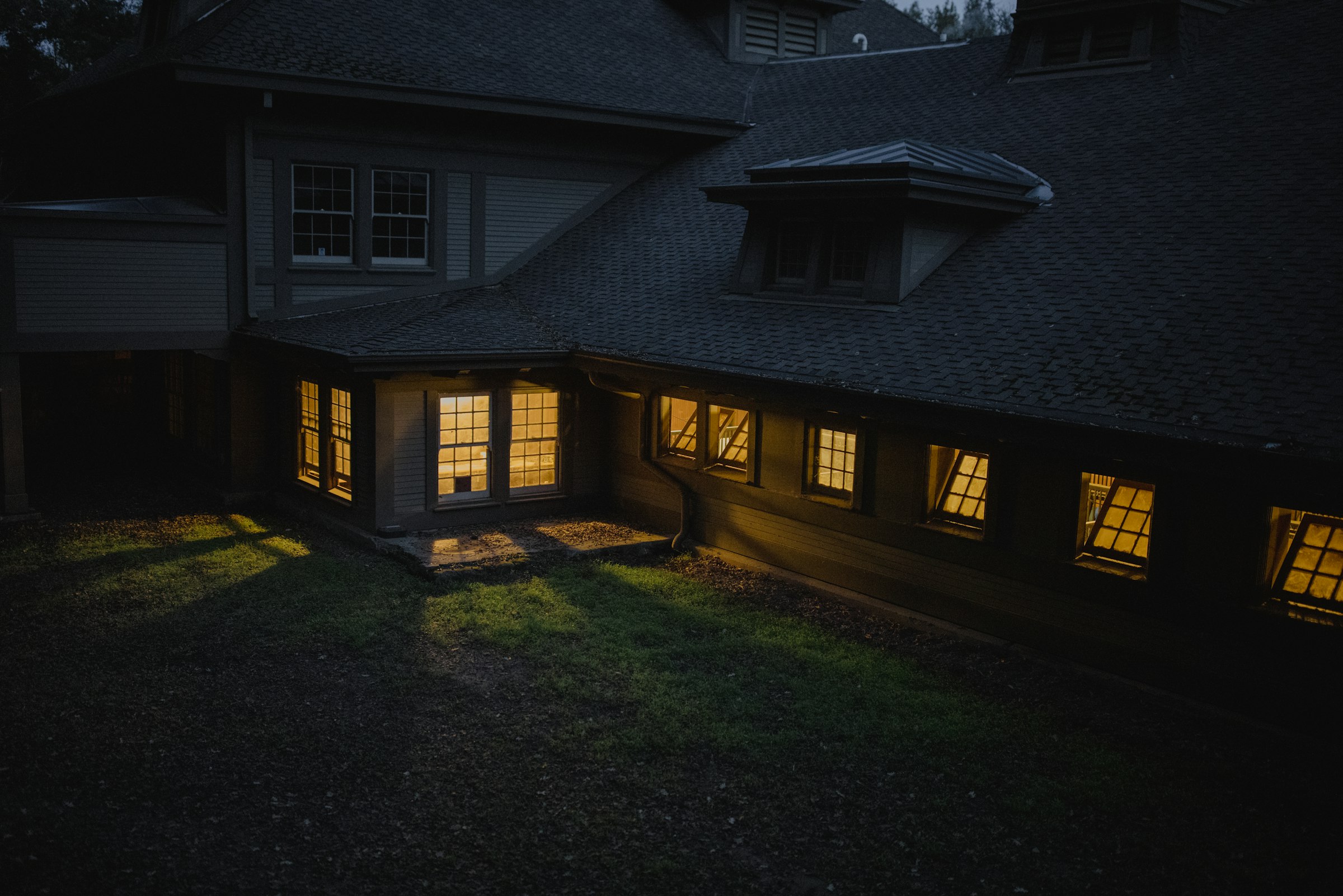 Home at dusk with warm light glowing from the windows